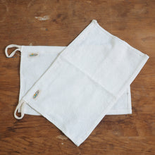 Load image into Gallery viewer, White drawstring bag on a wooden surface