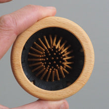 Load image into Gallery viewer, Hand holding a wooden brush with bristles against a gray background