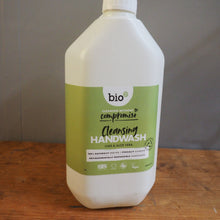 Load image into Gallery viewer, A bottle of bio compendium cleansing handwash with a white plastic body and a green label, shown lying on a wooden surface next to a gray floor.