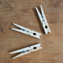 Load image into Gallery viewer, Three wooden clothespins on a wooden surface