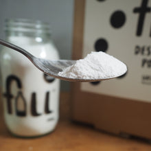 Load image into Gallery viewer, Spoon with white destainer powder above a bottle labeled 'fill' on a wooden surface.