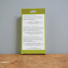 Load image into Gallery viewer, Green product packaging with text on a wooden surface and gray background