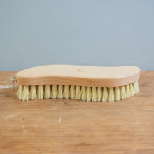 Load image into Gallery viewer, Bristle brush leaning against a wooden surface with a gray wall in the background