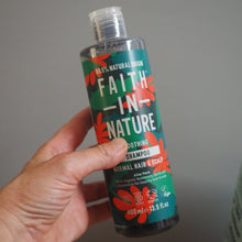 Load image into Gallery viewer, Hand holding a bottle labeled 'Faith in Nature' against a neutral background