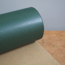 Load image into Gallery viewer, Roll of green vinyl wrap on a cardboard sheet with a gray background