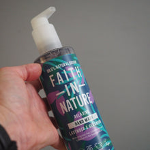 Load image into Gallery viewer, Hand holding a bottle of Fath-Nature hand soap with a pump on a gray background