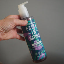 Load image into Gallery viewer, Hand holding a bottle of 'Faith in Nature' hand wash against a gray background