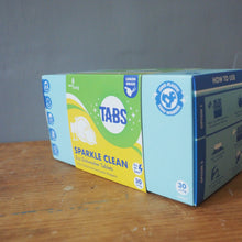 Load image into Gallery viewer, A box of TABS Sparkle Clean dishwasher tablets, showing the front and side panels, placed on a wooden tabletop against a gray wall.