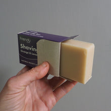 Load image into Gallery viewer, Orange &amp; Lavender Shaving Bar held in hand in purple box 
