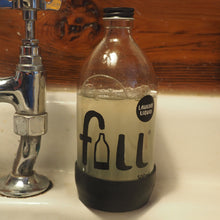 Load image into Gallery viewer, Glass bottle labeled 'full' next to a faucet on a wooden surface
