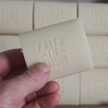 Load image into Gallery viewer, Hand holding a bar of soap with 'Faith in Nature' branding, in front of a box containing more bars.
