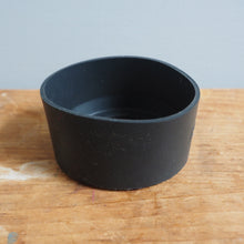 Load image into Gallery viewer, Black silicon ring on a wooden surface with a light gray background
