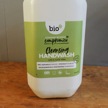 Load image into Gallery viewer, A bottle of bio-composite handwash with a white body and a green label, lying on a wooden surface next to a gray floor.
