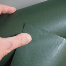 Load image into Gallery viewer, Green textured material being held by a hand on a wooden surface

