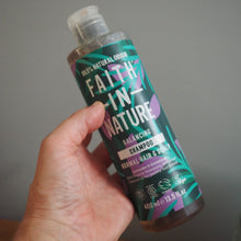 Load image into Gallery viewer, Hand holding a bottle of Faith in Nature shampoo against a neutral background
