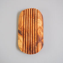 Load image into Gallery viewer, Wooden cutting board with a ribbed texture on a gray background
