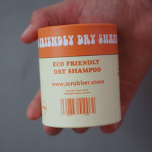 Load image into Gallery viewer, A hand holding a white plastic jar of Scrubber Store Eco Friendly Dry Shampoo against a plain gray background.
