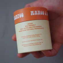 Load image into Gallery viewer, A hand holding a jar of BAMFOO Vegan Eco Friendly Bamboo Powder against a plain gray background.
