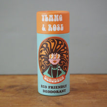Load image into Gallery viewer, A cylindrical container of Schubben Ylang &amp; Rose Eco Friendly Deodorant standing on a wooden surface against a plain gray wall.
